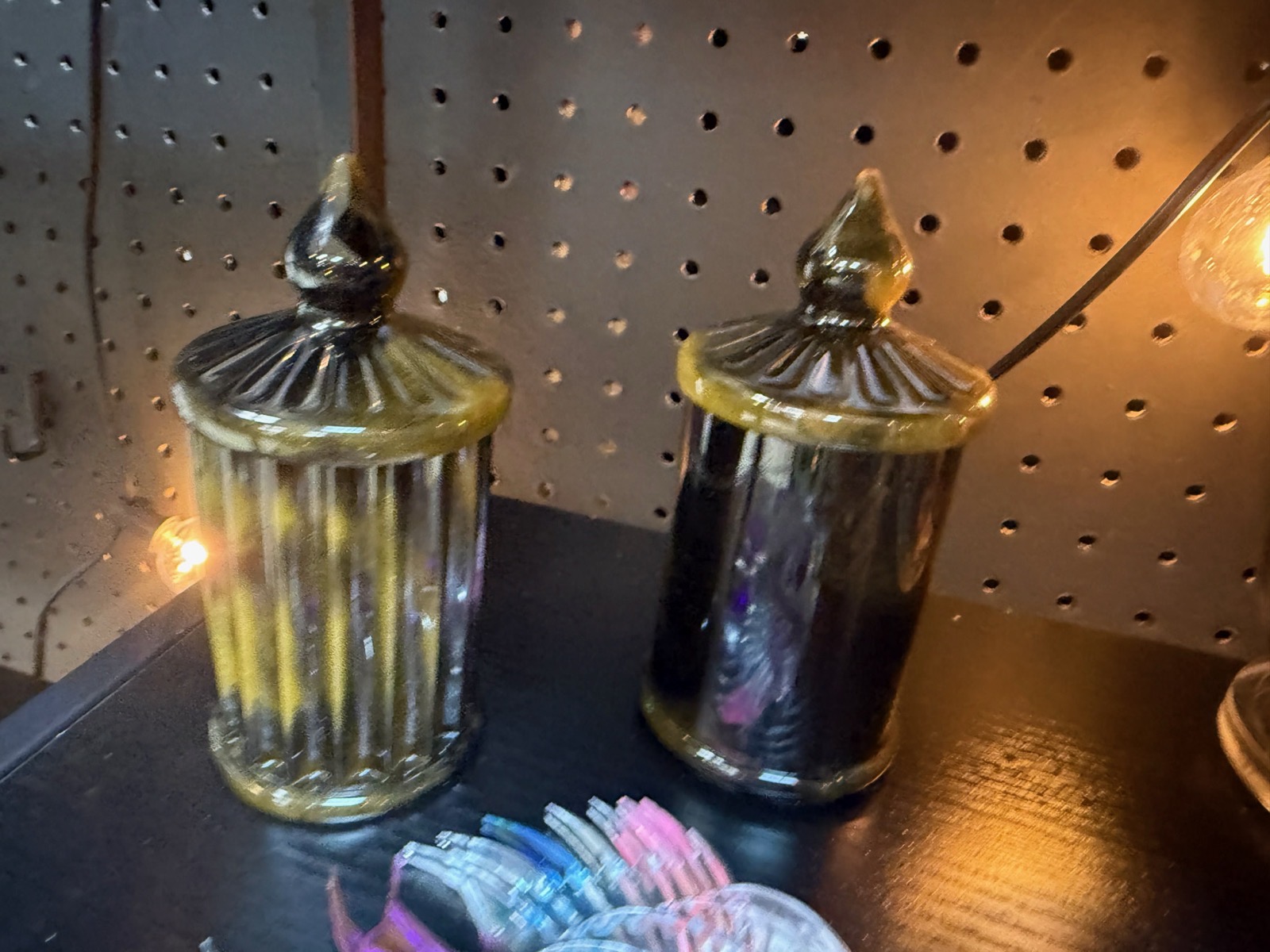 Pair of ribbed translucent resin canisters with finial lids in warm amber light